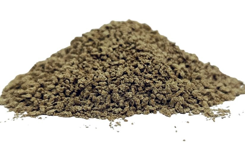 Chamomile granules (Matricaria chamomilla) pile on white background